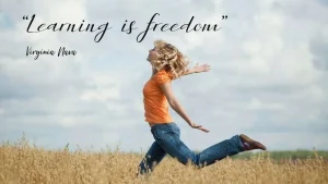 A girl in a orange t-shirt and jeans is running amid a wheat field. Above her, there's a text that reads learning is freedom